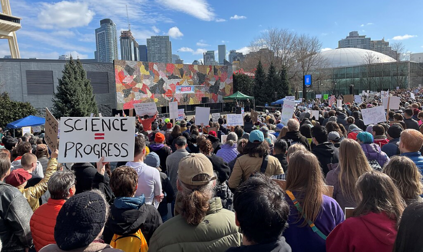 A photograph of a crowd of people at the Stand Up For Science protest in Seattle, Washington on 07 March 2025. Many people are holding signs, one of which says 