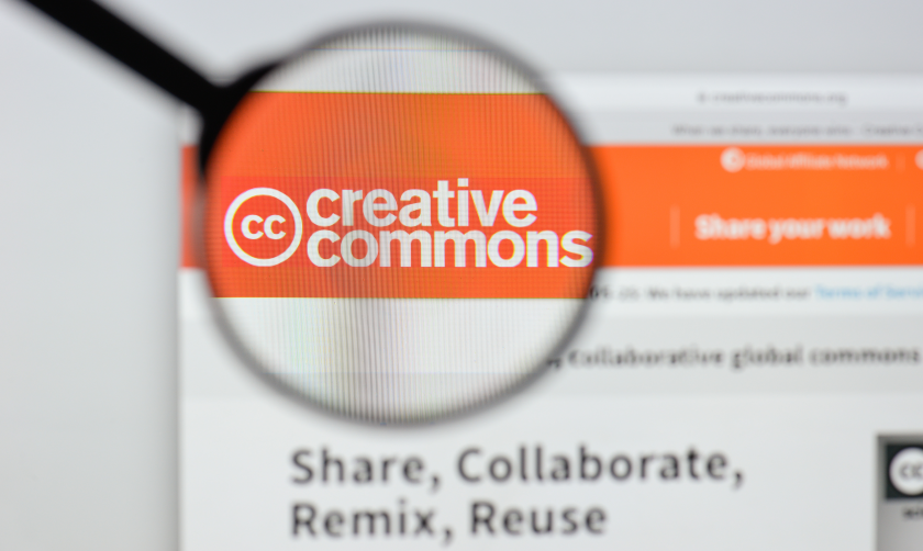 The Creative Commons logo at the upper left hand corner of a web page, viewed through a magnifying glass 