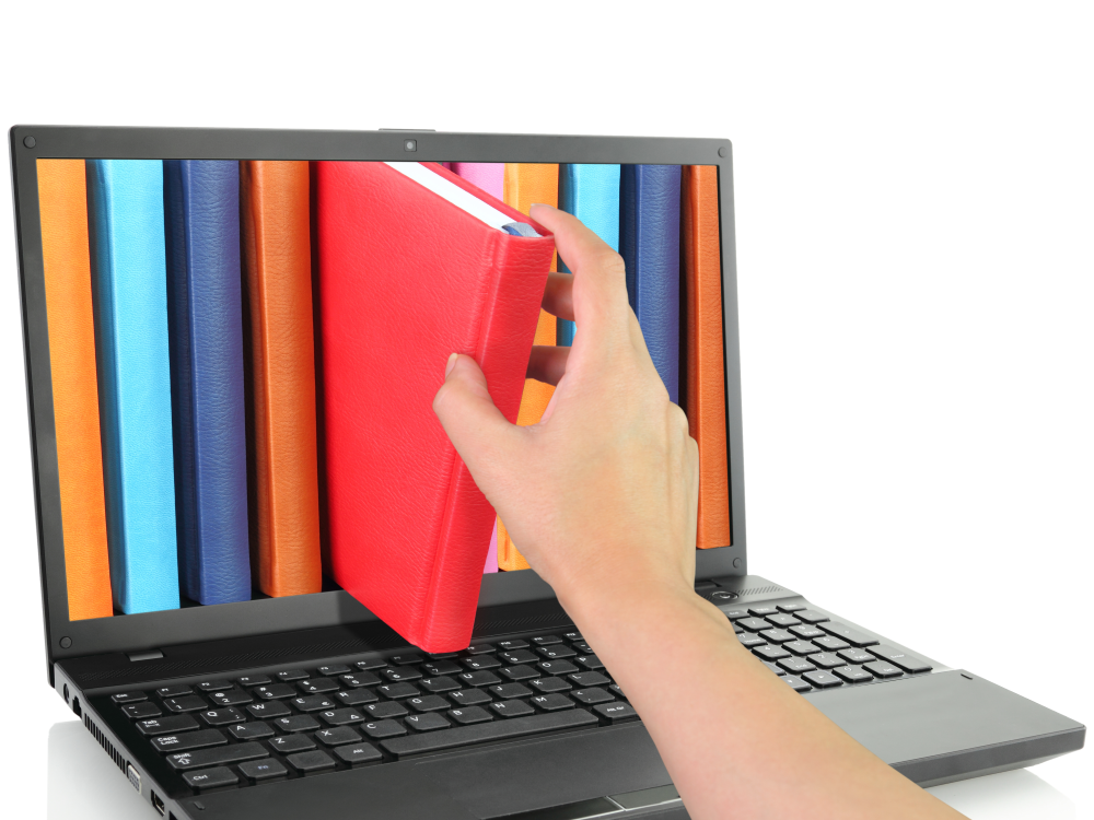 Photo illustration of a hand pulling a book out of a laptop screen 