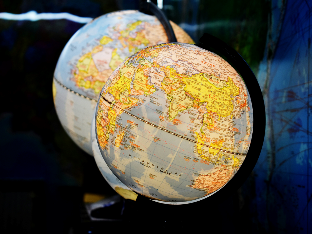 Two illuminated globes, the one in front displaying Africa, India, and Indonesia.