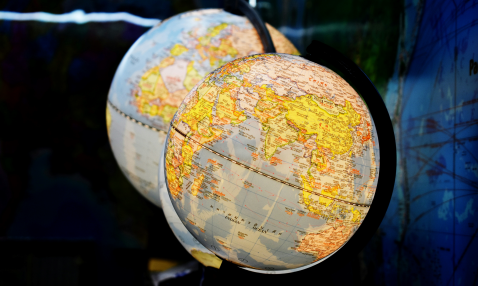 Two illuminated globes, the one in front displaying Africa, India, and Indonesia.