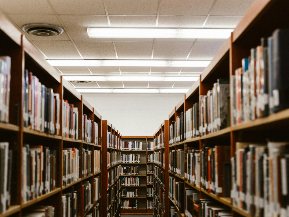 A photograph of a library aisle narrowing to what appears to be a dead end