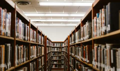 A photograph of a library aisle narrowing to what appears to be a dead end